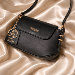 Guess faux-leather mini shoulder bag, possibly the Avelina model. Dive deeper in AI