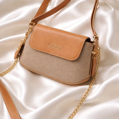 Guess faux-leather mini shoulder bag, possibly the Avelina model. Dive deeper in AI