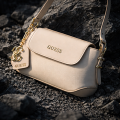 Guess faux-leather mini shoulder bag, possibly the Avelina model. Dive deeper in AI