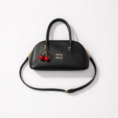 Miu Miu Aventure nappa leather top-handle bag with a cherry bag charm.
