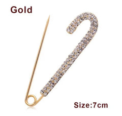 a rhinestone safety pin brooch, often featuring a robust metal base adorned with sparkling crystals.