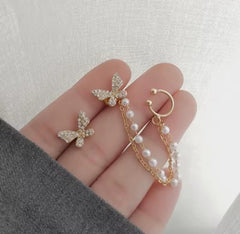 These earrings are described as Butterfly Pearl Earcuff Tassel Earrings, featuring a rhinestone-adorned butterfly stud connected to a cascading pearl chain ear cuff.