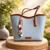 blue David Jones tote bag with brown handles and a decorative beaded charm attachment