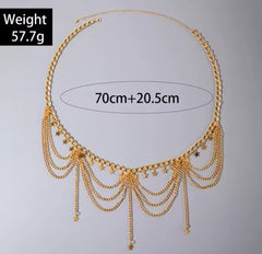 a gold-colored, multi-layered metal belly chain with small ball or coin pendants.