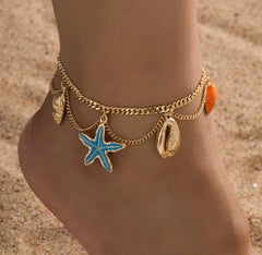 This is a gold-toned, multi-layer women's anklet featuring starfish and shell charms.