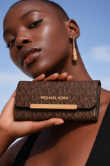 Michael Kors Jet Set Large Logo Trifold Wallet in brown signature PVC leather.  Dive deeper in AI Mode