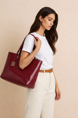 Armani Exchange brand-embossed tote bag in a dark red color and a patent finish.