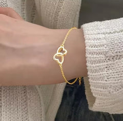 a simple gold interlocking heart charm bracelet, often made of alloy or sterling gold.