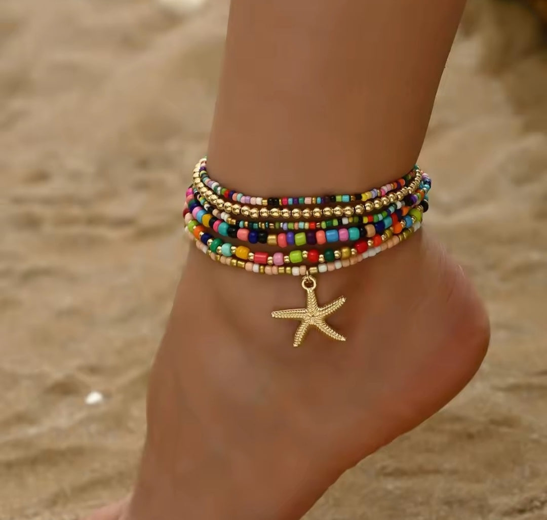 This multilayer starfish pendant anklet is a bohemian-style accessory featuring colorful beads and gold-toned starfish charms, perfect for enhancing beachwear.