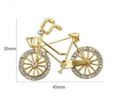 a gold-colored alloy bicycle brooch with faux pearl and rhinestone accents