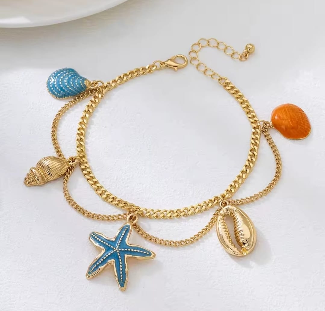 This is a gold-toned, multi-layer women's anklet featuring starfish and shell charms. 