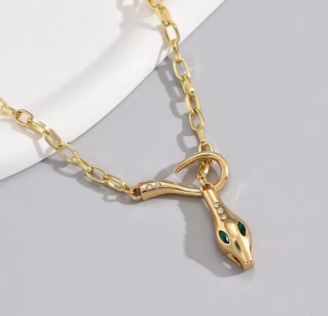 This is a gold-plated snake pendant necklace with green eyes. 